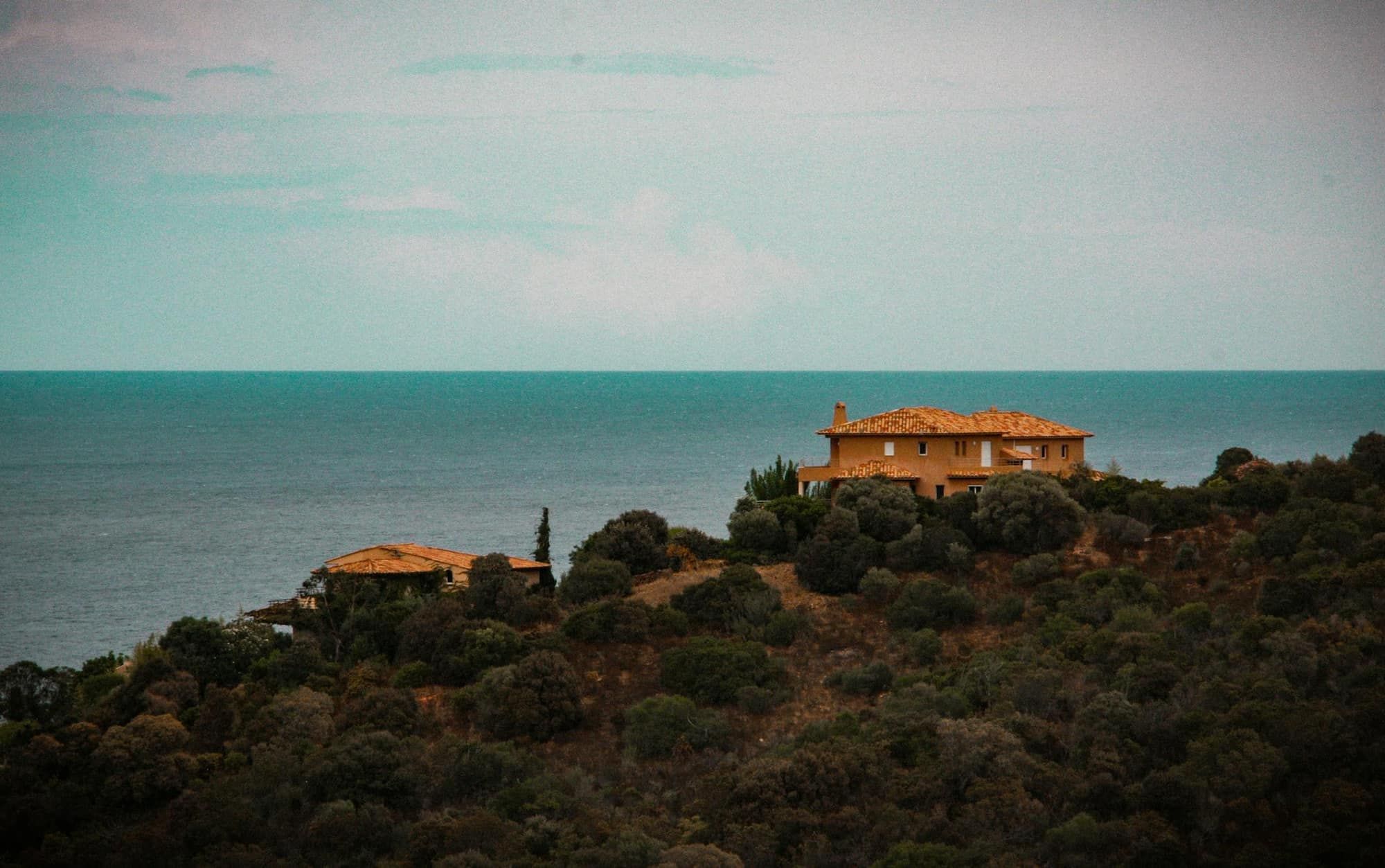 Villa aux murs ocre sur une colline boisée dominant la Méditerranée